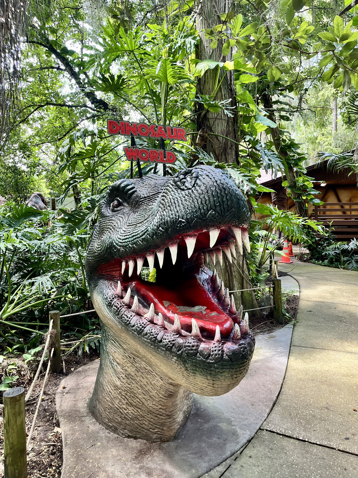 t-rex with mouth open and Dinosaur World sign